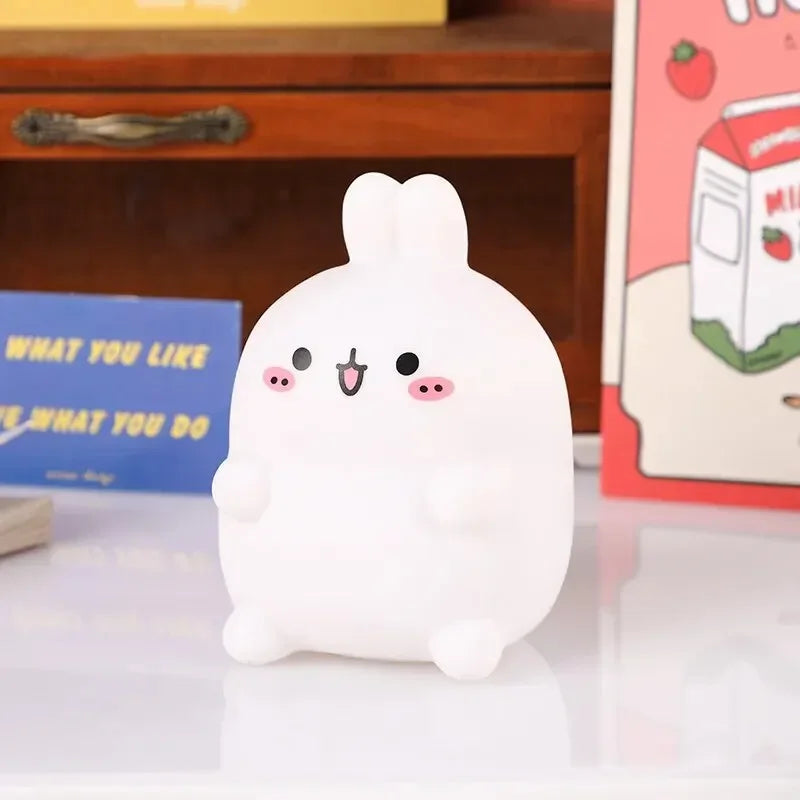 Cute white cartoon-style night light on a surface with a blurred background